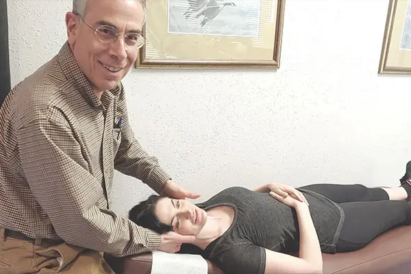 Dr. Siegel gently adjusting a patient's neck